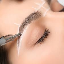 Close-up of cosmetic eyebrow tattooing with white guide lines on skin